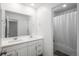 The bright bathroom boasts double sinks, a large mirror and a shower with curtain in the corner at 3365 N Coolidge Way, Aurora, CO 80019