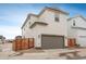 Two-story home featuring a gray attached garage, light siding, new landscaping, and a fenced yard on a concrete driveway at 3365 N Coolidge Way, Aurora, CO 80019