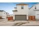 Neutral two-story home featuring an attached two-car garage, light siding, new landscaping, and a fenced yard at 3365 N Coolidge Way, Aurora, CO 80019
