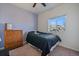 Cozy bedroom features a ceiling fan, neutral paint and a window allowing natural light, complemented by a wooden dresser at 42855 Hawktree Cir, Elizabeth, CO 80107