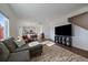 Open-concept living space featuring a large sectional sofa and views into the kitchen at 42855 Hawktree Cir, Elizabeth, CO 80107