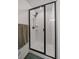 Clean shower with white tiling, black trim, and a modern shower head, offering a sleek and functional design at 42855 Hawktree Cir, Elizabeth, CO 80107