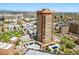 Stunning aerial view of a tall residential building and outdoor amenities including a pool and green spaces at 100 Park Ave # 907, Denver, CO 80205