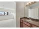 Bathroom featuring granite countertop and wood vanity next to bedroom with city view at 100 Park Ave # 907, Denver, CO 80205