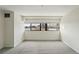 Bedroom featuring neutral carpet, modern sconces, and cityscape views from a large window at 100 Park Ave # 907, Denver, CO 80205