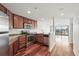 Modern kitchen featuring stainless steel appliances, granite countertops, and rich wood cabinetry and flooring at 100 Park Ave # 907, Denver, CO 80205