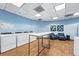 Bright laundry room featuring multiple washers, folding table, and cozy seating area for resident's convenience at 100 Park Ave # 907, Denver, CO 80205
