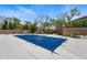 Inviting community pool with a blue cover, surrounded by mature trees, lounge chairs, and outdoor grill at 100 Park Ave # 907, Denver, CO 80205