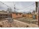 Backyard featuring a brick patio, garage, wooden fence, and metal table and chairs at 1229 Josephine St, Denver, CO 80206