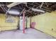 Unfinished basement with exposed ceiling, concrete floor, water heater, and support beam at 1229 Josephine St, Denver, CO 80206
