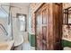 Vintage bathroom with clawfoot tub, floral wallpaper, and a large wooden wardrobe at 1229 Josephine St, Denver, CO 80206