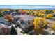 Spacious three-story townhome with a tile roof, two-car garage, and colorful fall foliage at 7704 E 25Th Ave, Denver, CO 80238