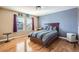 A comfy bedroom with hardwood floors and a large window providing natural light and outside views at 10726 Amesbury Way, Highlands Ranch, CO 80126
