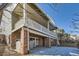 Multi-story home exterior showcasing a covered patio, brick foundation, and access to the backyard at 10726 Amesbury Way, Highlands Ranch, CO 80126