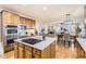 Bright kitchen boasts a large island with quartz countertop and a view of living and dining area at 10726 Amesbury Way, Highlands Ranch, CO 80126