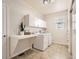 Bright laundry room with white cabinets, tile floors, and modern appliances at 10726 Amesbury Way, Highlands Ranch, CO 80126