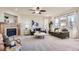 Cozy living room with a fireplace, ceiling fan, and large windows for natural light at 10726 Amesbury Way, Highlands Ranch, CO 80126