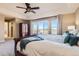 A well-lit main bedroom featuring a king bed, a ceiling fan, and access to the private balcony at 10726 Amesbury Way, Highlands Ranch, CO 80126