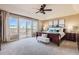 Bright main bedroom with ceiling fan, a king bed, and sliding glass doors that lead to a private balcony at 10726 Amesbury Way, Highlands Ranch, CO 80126