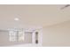 A well-lit room with two large windows, neutral carpet, and a white door at 10726 Amesbury Way, Highlands Ranch, CO 80126
