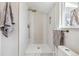 Updated bathroom showcasing an elegant shower with tiled walls and new fixtures at 3756 S Chase St, Denver, CO 80235