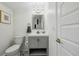 Updated bathroom with a grey vanity, new fixtures, and white walls at 3756 S Chase St, Denver, CO 80235