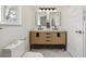 Updated bathroom with double vanity, modern fixtures, and sleek lighting at 3756 S Chase St, Denver, CO 80235
