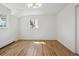 Bright, empty bedroom featuring hardwood floors and two windows at 3756 S Chase St, Denver, CO 80235