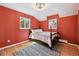 Cozy bedroom with a wood frame bed, two windows, and a vintage rug at 3756 S Chase St, Denver, CO 80235