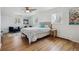 Bright bedroom featuring hardwood floors, a ceiling fan and large windows at 3756 S Chase St, Denver, CO 80235