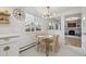 Bright dining area with wooden table, chairs, and chandelier near an outside window at 3756 S Chase St, Denver, CO 80235