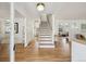 Open entryway with hardwood floors, staircase, and views into adjacent living spaces at 3756 S Chase St, Denver, CO 80235