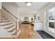 Bright foyer with staircase featuring hardwood floors and abundant natural light at 3756 S Chase St, Denver, CO 80235