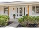 Inviting front entrance features a modern glass door, manicured shrubs, and stylish exterior lighting at 3756 S Chase St, Denver, CO 80235