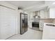 Modern white kitchen featuring stainless steel appliances and marble backsplash at 3756 S Chase St, Denver, CO 80235