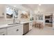 Bright kitchen with white cabinets, stainless steel appliances, and an adjacent dining area at 3756 S Chase St, Denver, CO 80235