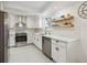 Modern kitchen featuring stainless steel appliances, white cabinetry, and stylish countertop accents at 3756 S Chase St, Denver, CO 80235