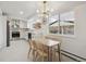 Spacious kitchen with stainless appliances, white cabinets, a dining area, and bright natural lighting at 3756 S Chase St, Denver, CO 80235