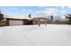 Back of a brick home, garage and pergola covered in snow in the winter at 2835 N Monaco Pkwy, Denver, CO 80207