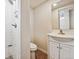 Bathroom featuring a tiled shower, toilet, and vanity with storage at 2835 N Monaco Pkwy, Denver, CO 80207