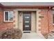 A close up of the brick facade and front door entrance of this cozy home at 2835 N Monaco Pkwy, Denver, CO 80207