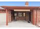 Brick garage with an outdoor portico and a mix of steel and wood doors at 2835 N Monaco Pkwy, Denver, CO 80207