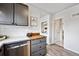 Cozy kitchen features light wood countertops, tile backsplash, and stainless steel dishwasher at 2835 N Monaco Pkwy, Denver, CO 80207