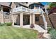Multi-level backyard with stone facade, covered patio, grassy area, and staircase to upper deck at 2916 Hiwall Ct, Castle Rock, CO 80109