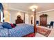 Spacious main bedroom featuring a four-poster bed, elegant decor, and ensuite bathroom at 2916 Hiwall Ct, Castle Rock, CO 80109