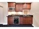 Convenient wet bar with custom cabinets, wine storage, microwave, and elegant countertop at 2916 Hiwall Ct, Castle Rock, CO 80109