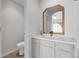 The bright bathroom features a single vanity, a decorative mirror and a toilet at 1409 Carlyle Park Cir, Highlands Ranch, CO 80129