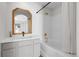 Bright bathroom features white subway tile shower surround, gold fixtures, decorative mirror, and vanity at 1409 Carlyle Park Cir, Highlands Ranch, CO 80129