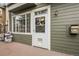 Home exterior with green siding, a brick patio, and multiple windows for natural light at 1409 Carlyle Park Cir, Highlands Ranch, CO 80129