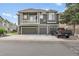 Modern townhome showing multiple garage doors and a pickup truck parked in the driveway at 1409 Carlyle Park Cir, Highlands Ranch, CO 80129